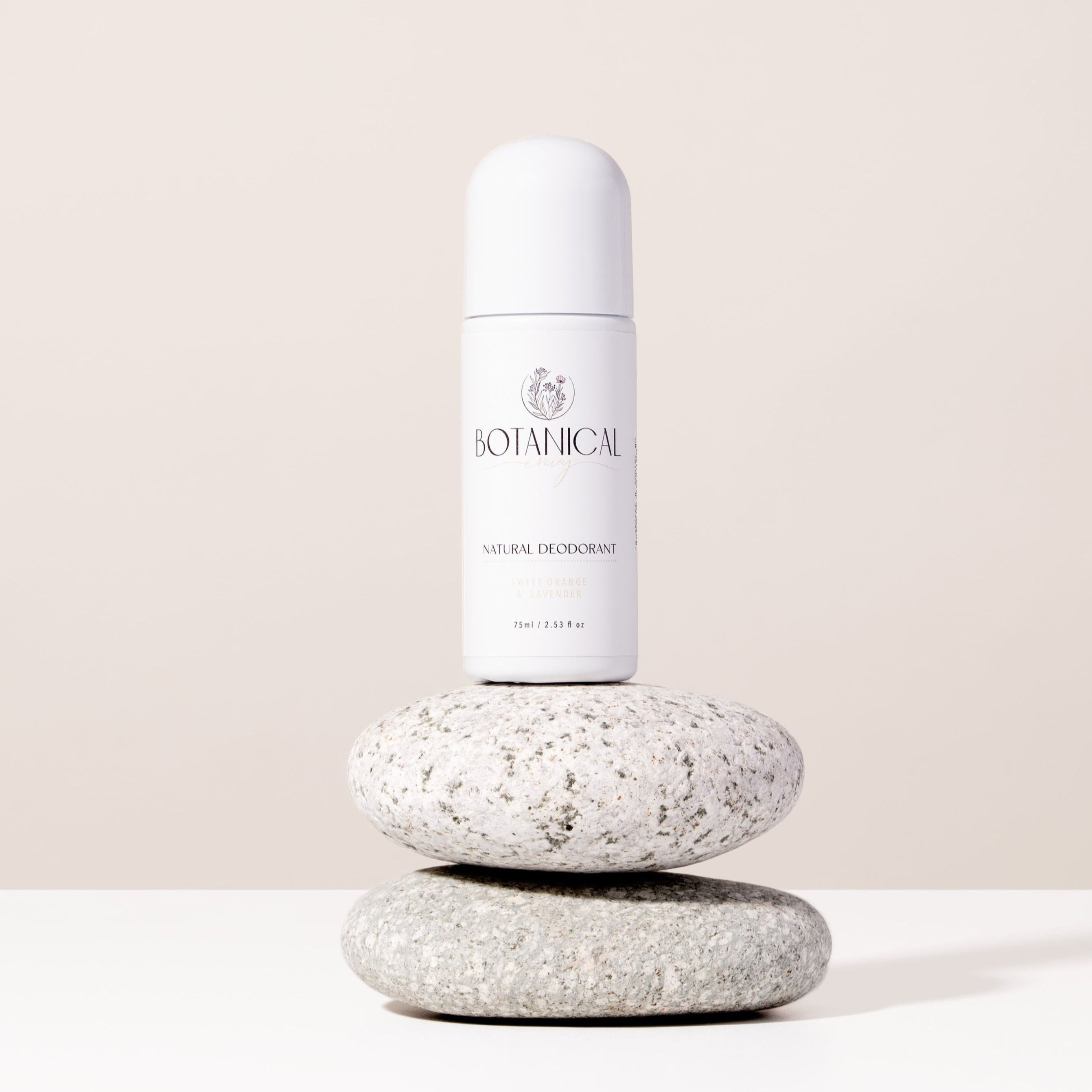 White deodorant bottle on top of two stones beige background