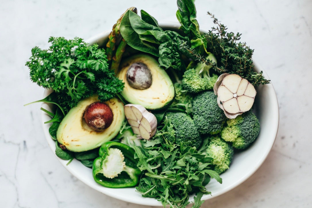 A plate full of salad greens and avocado