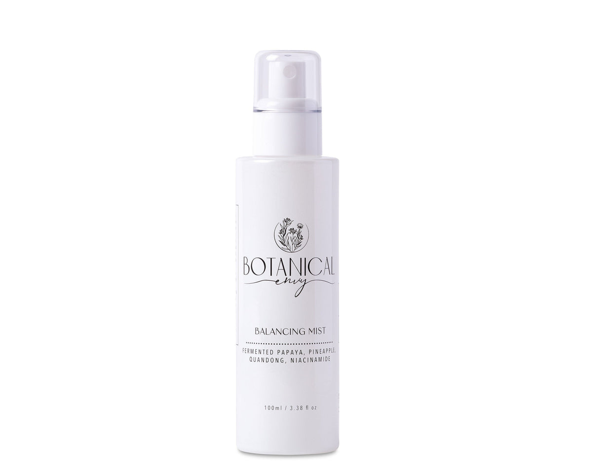 A white glass bottle of balancing mist against a white background
