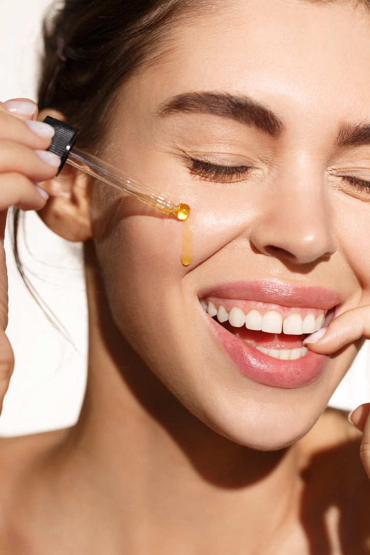 A lady applying oil elixir on her face