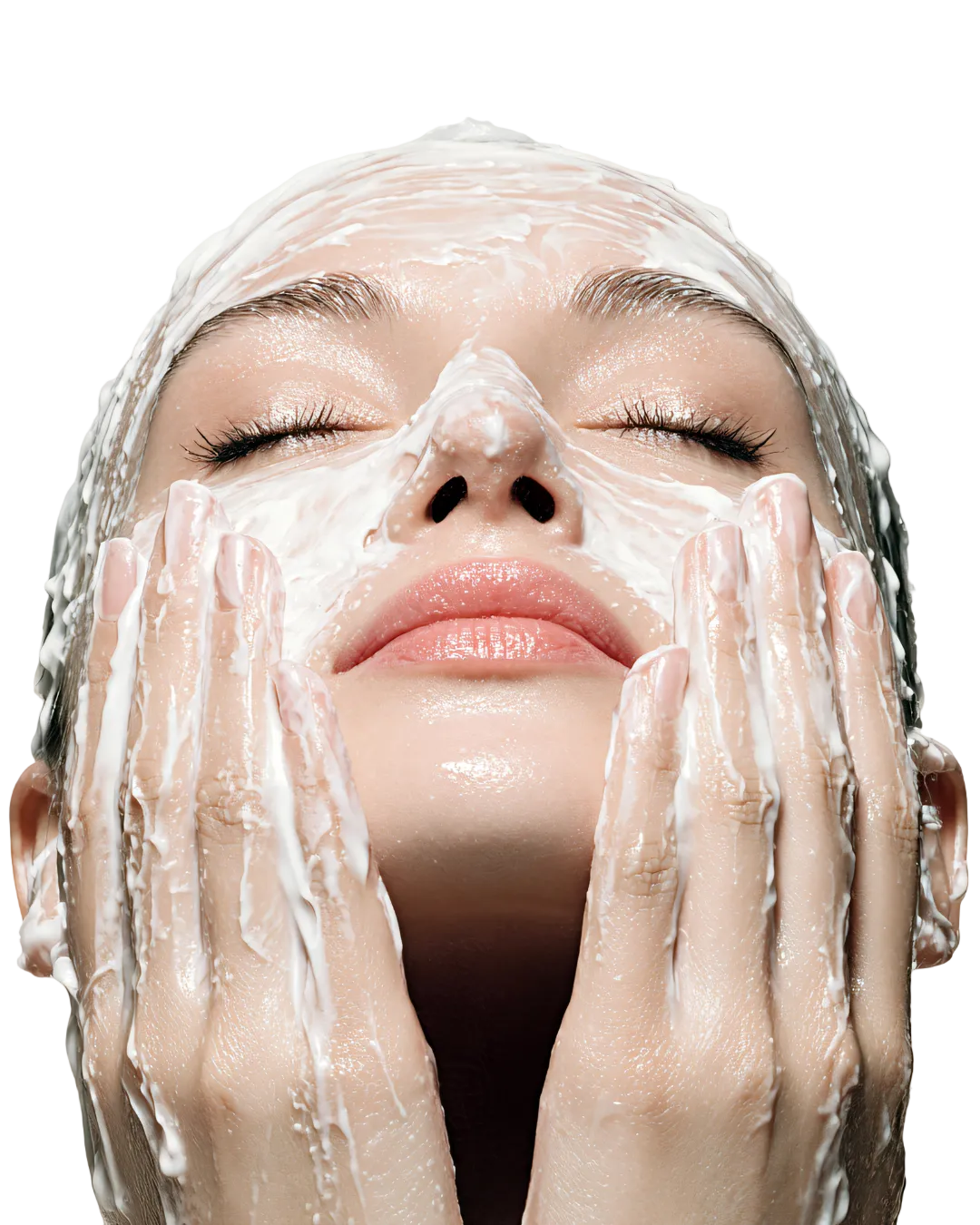 A lady looking up with her eyes closed with lotion on her face and hands.