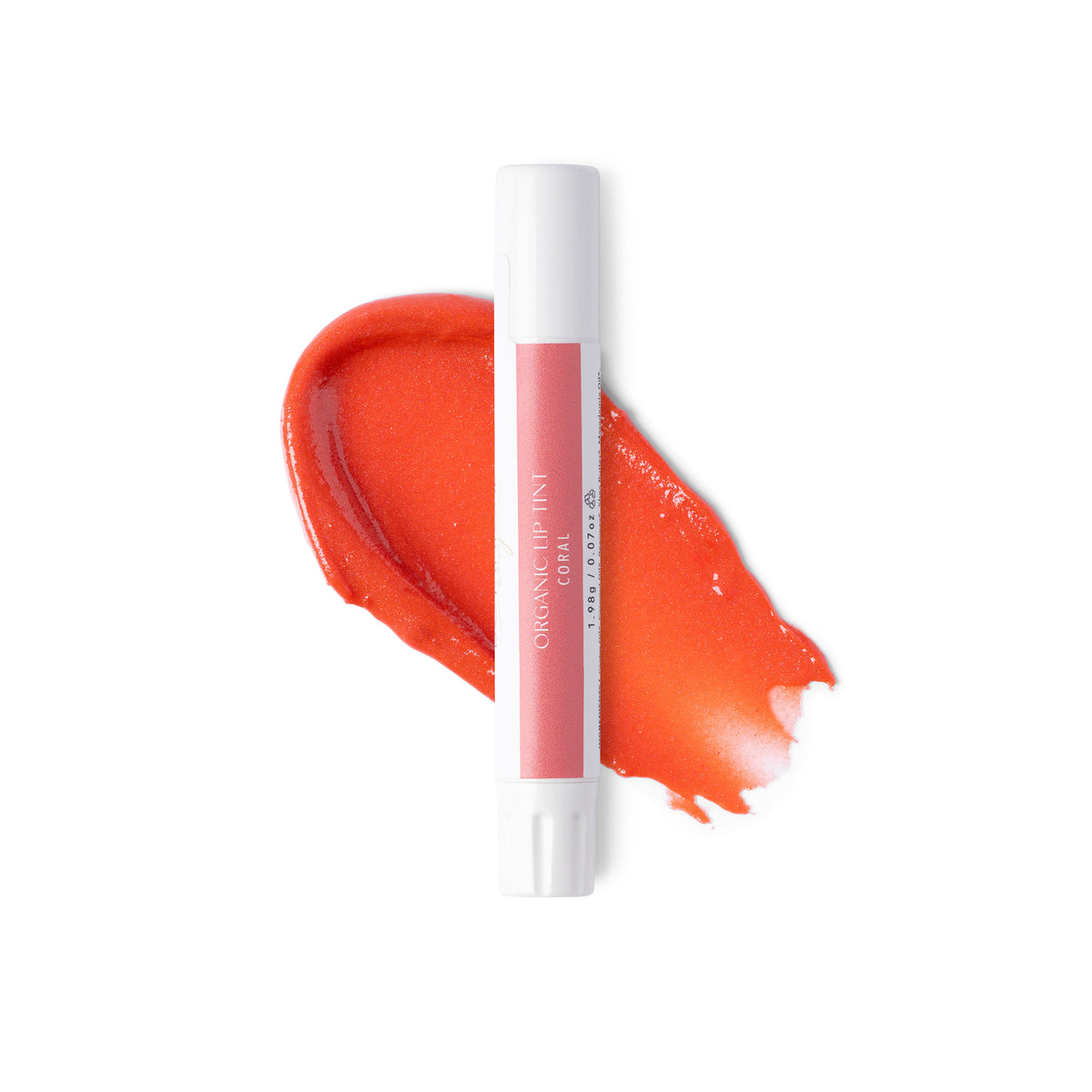 A white tube of coral lip tint against a swatch of colour and a white background