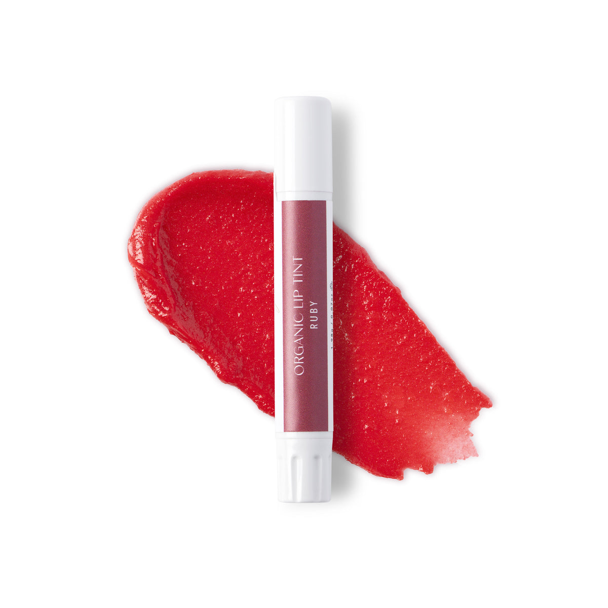 A white tube of ruby lip tint against a swatch of colour and a white background