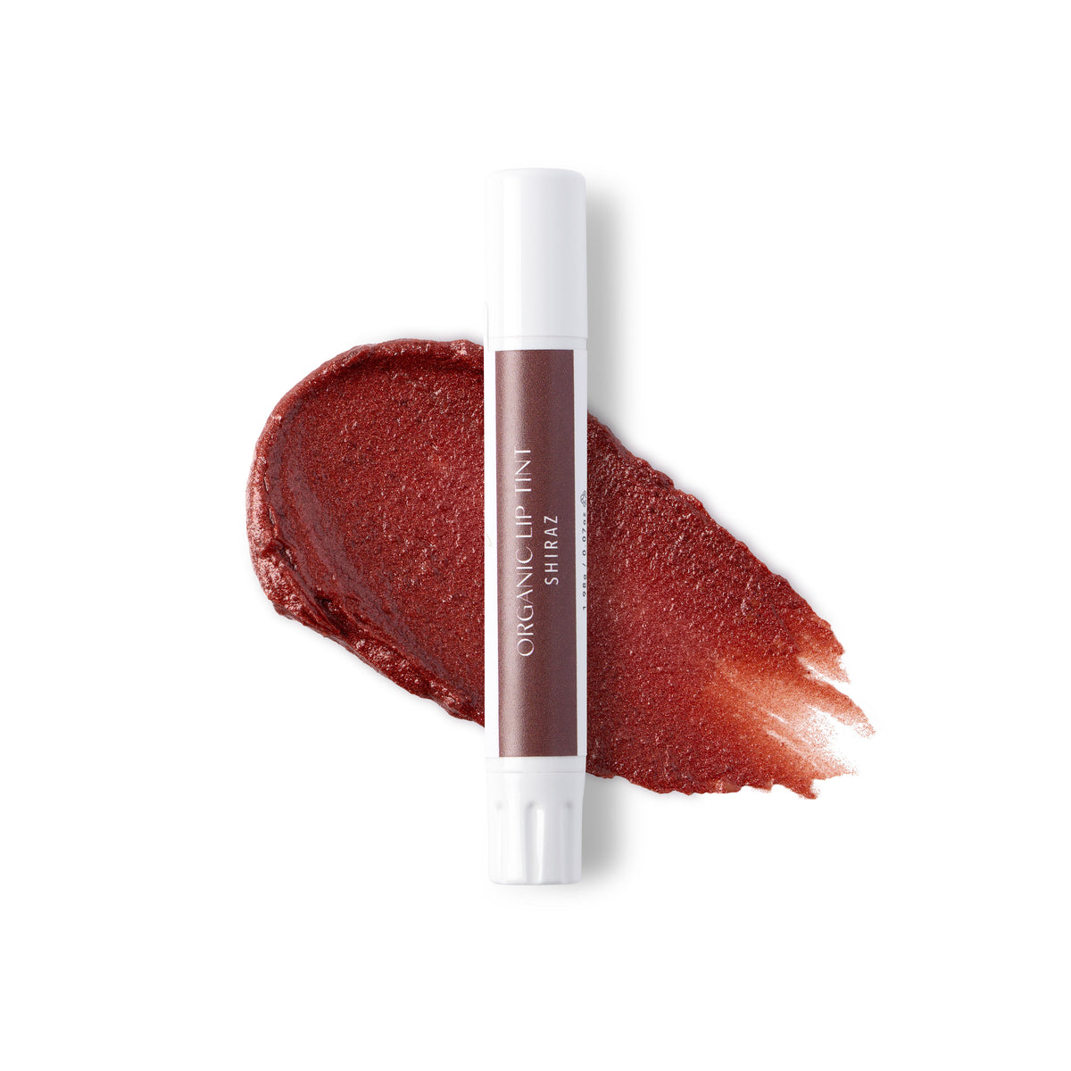 A white tube of shiraz lip tint against a swatch of colour and a white background