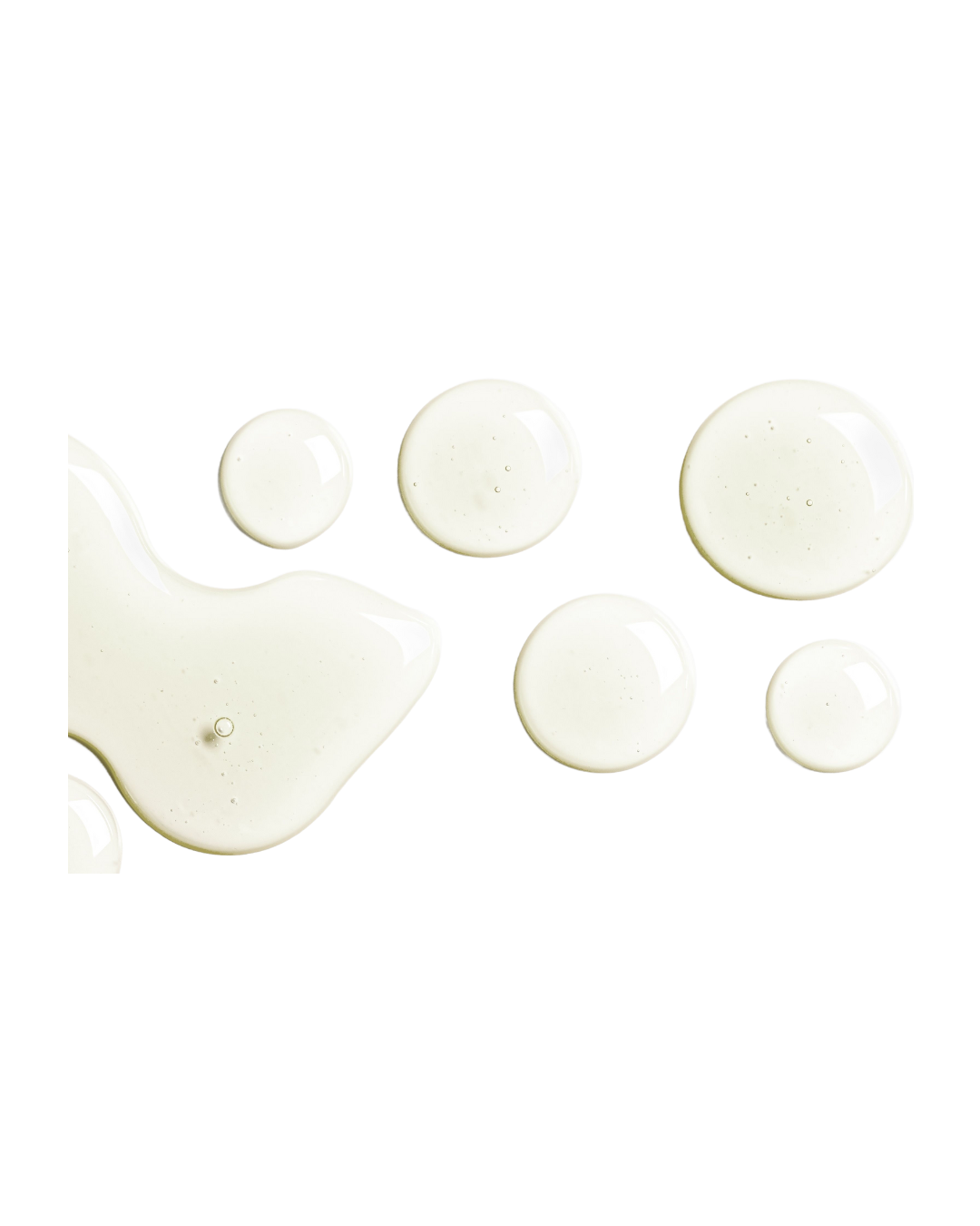 Drops of light yellow Botanical Envy Vitamin C serum against a white background