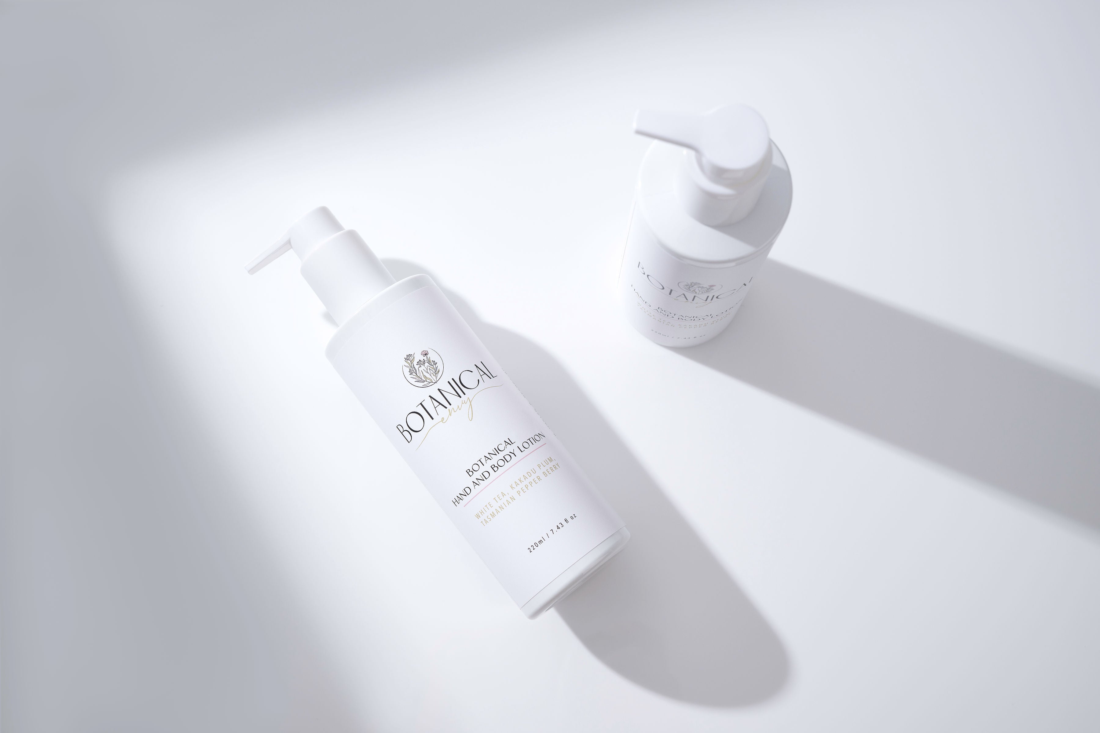 Two white Hand and body lotion with shadow lines on a white background