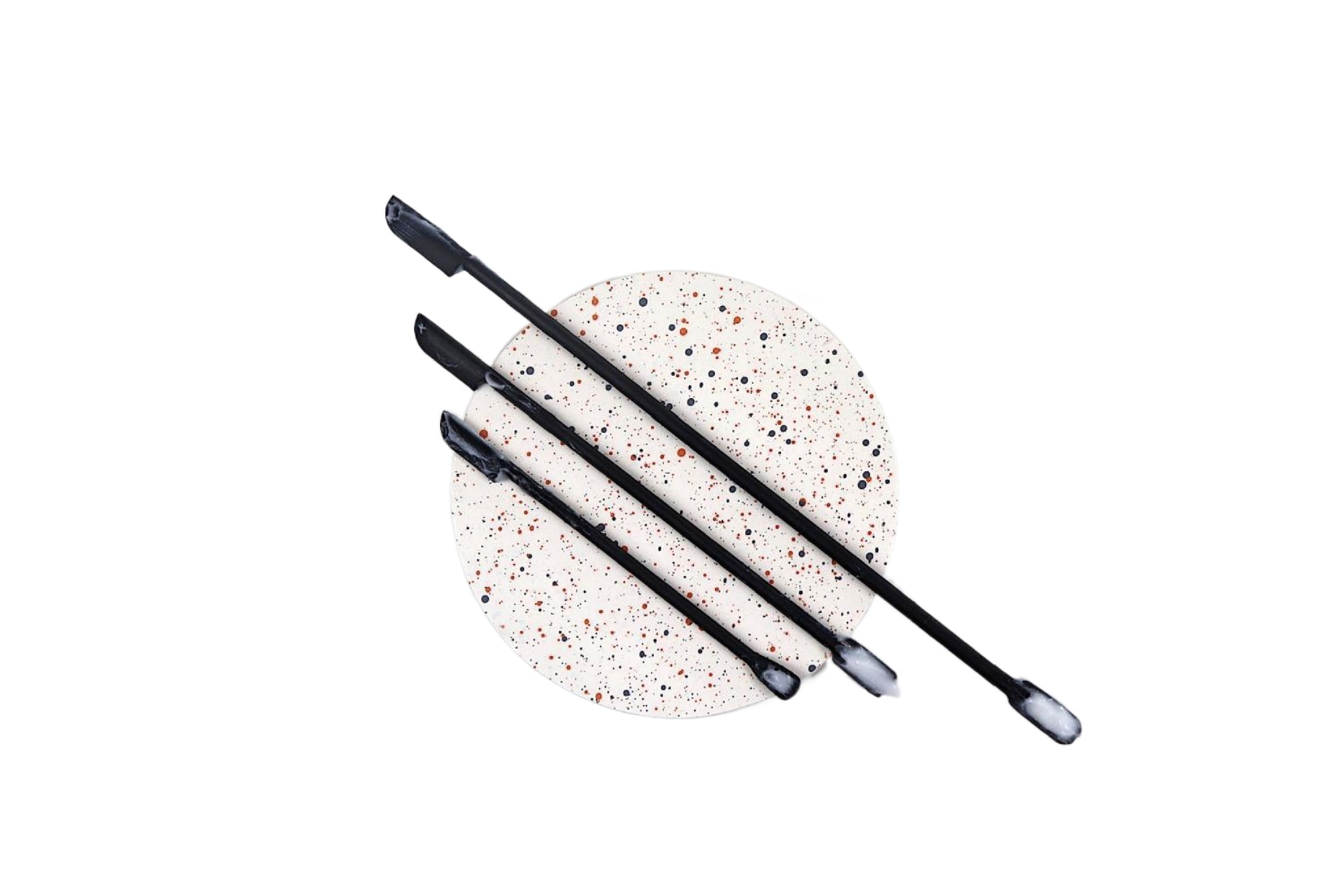 Set of 3 silicon skincare spatulas on a round plate with paint specs white background